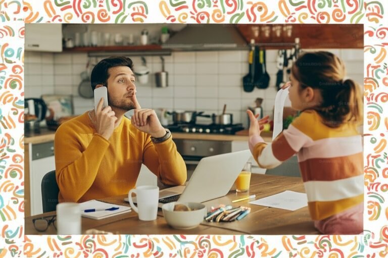 Father working from home on laptop and phone, gesturing for quiet as his child talks to him in the kitchen.